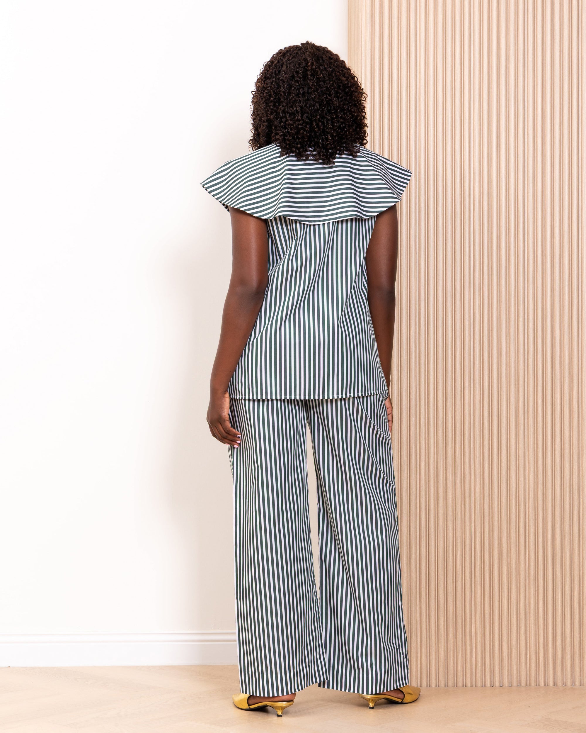 Back view of navy stripe co-ord set by Kras the Label showing wide-leg trousers and ruffle collar top