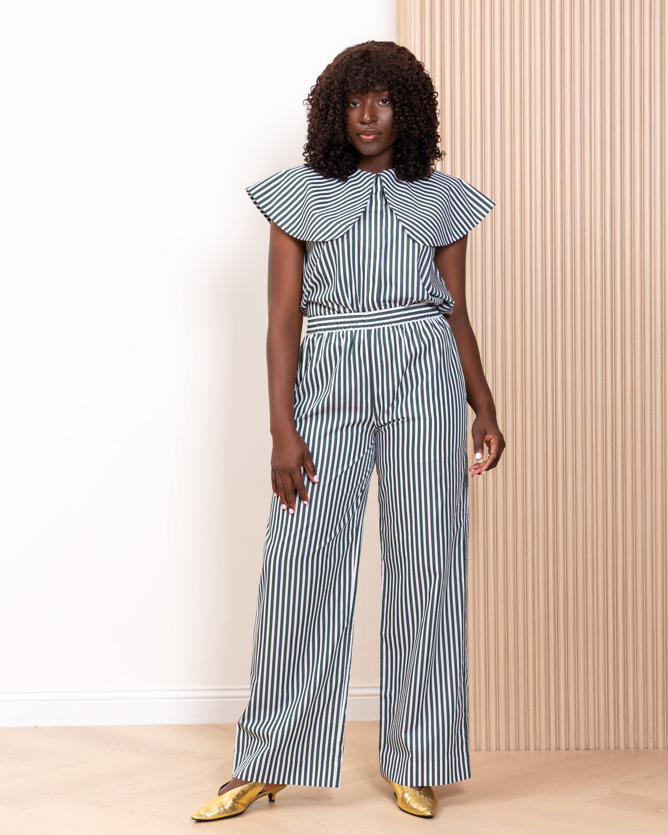 Model wearing navy stripe co-ord set with ruffle collar top and wide-leg trousers by Kras the Label