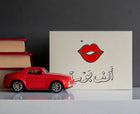 Greeting card featuring a contemporary Arabic love phrase "A Thousand Kisses" in a colourful graphic composition
