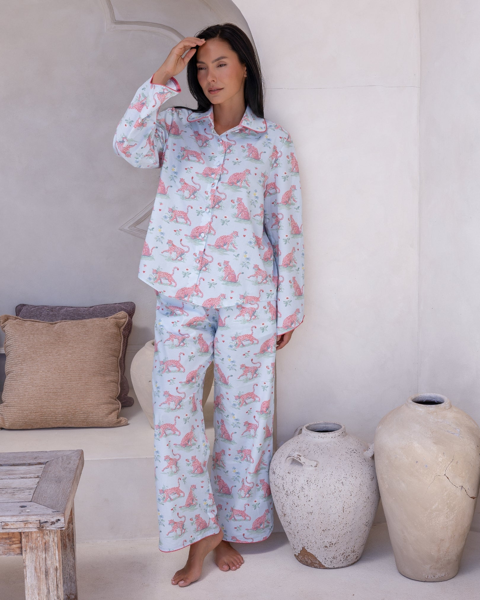 Layla Blue Long PJ Set – full-length view of model standing with hand raised to forehead, wearing pale blue long pyjama set with all-over pink leopard print and pink contrast piping