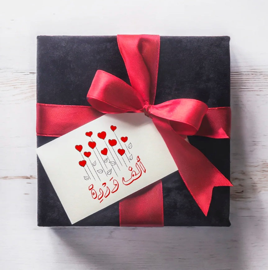 Greeting card featuring a contemporary Arabic love phrase "A Thousand Roses" in a colourful graphic composition