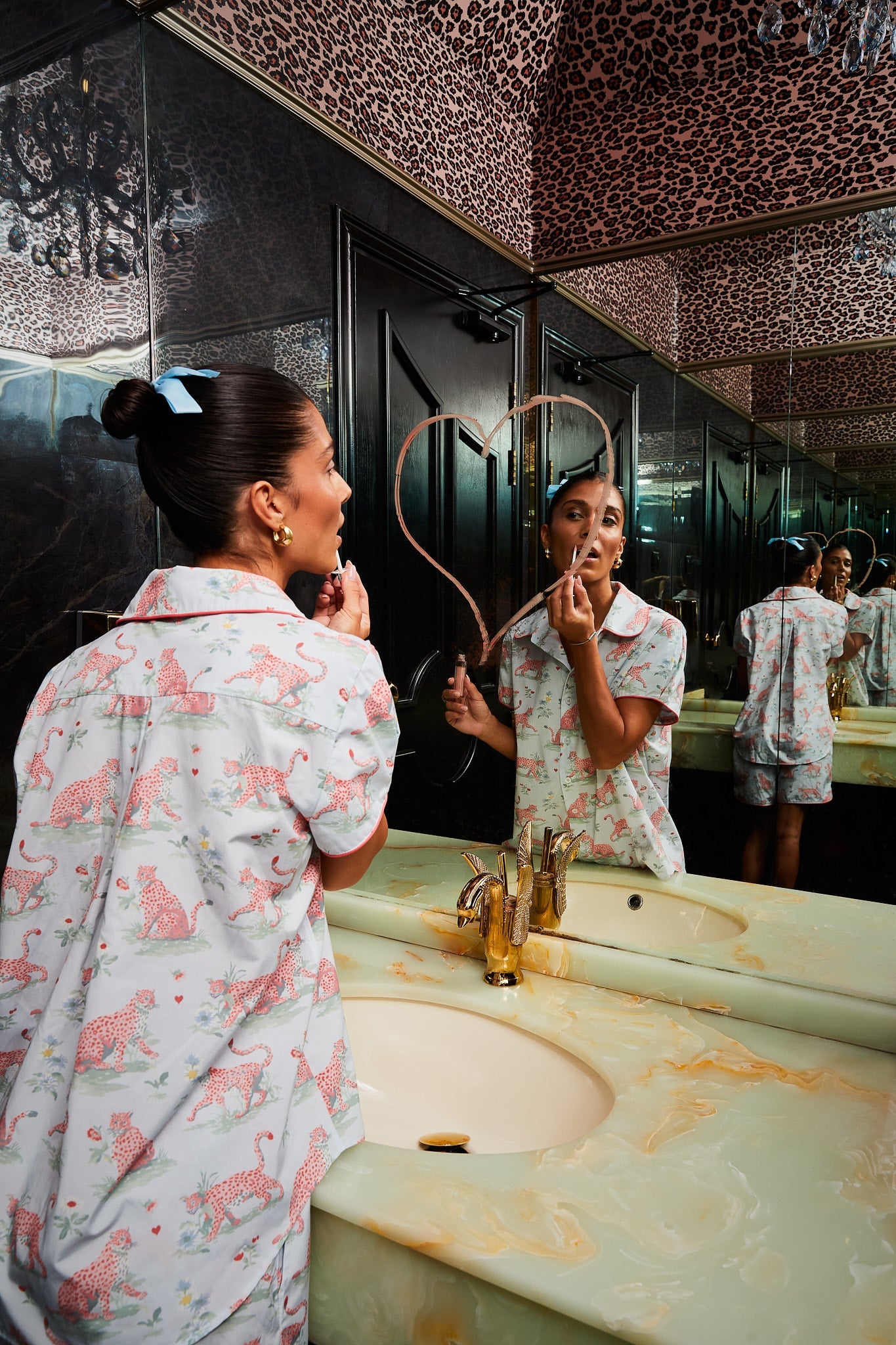 Model in Layla Blue Short Pyjama Set applying makeup in a glamorous mirrored bathroom"