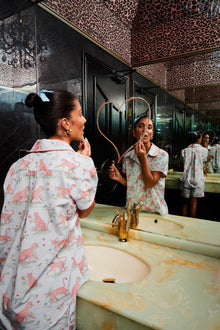 Model in Layla Blue Short Pyjama Set applying makeup in a glamorous mirrored bathroom"