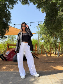 Model posing outside wearing the EOS X Remy White Joggers
