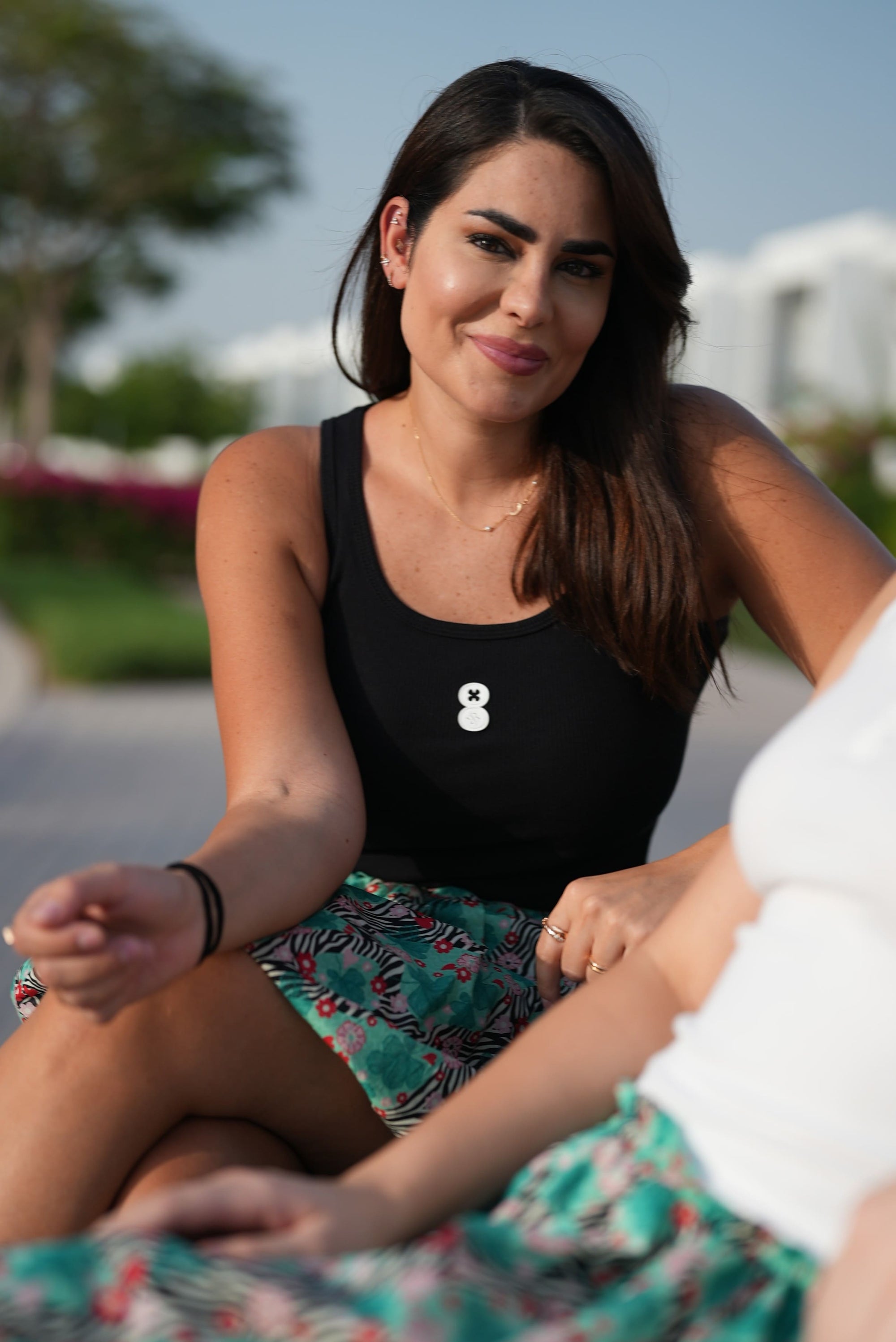Model sitting down wearing the EOS x Remy Ribbed Tank Top