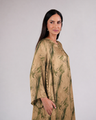Model wearing Mirelle olive and gold silk dress with an artistic abstract print