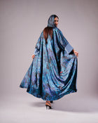 1. Back view of the flowing blue patterned abaya with matching headscarf.