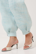 Close-up detail shot of the cuffed hems with metal buttons of the Portofino Mare Balloon Pants by Rèmy Suits