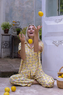 Model wearing the Love Letters x Nour Pyjama Set with a yellow floral print and wide-leg trousers.
