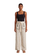 Model is wearing the Aether Linen Trouser in Beige by Muda Clothing