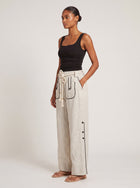 Side profile of model wearing the Aether Linen Trouser in beige