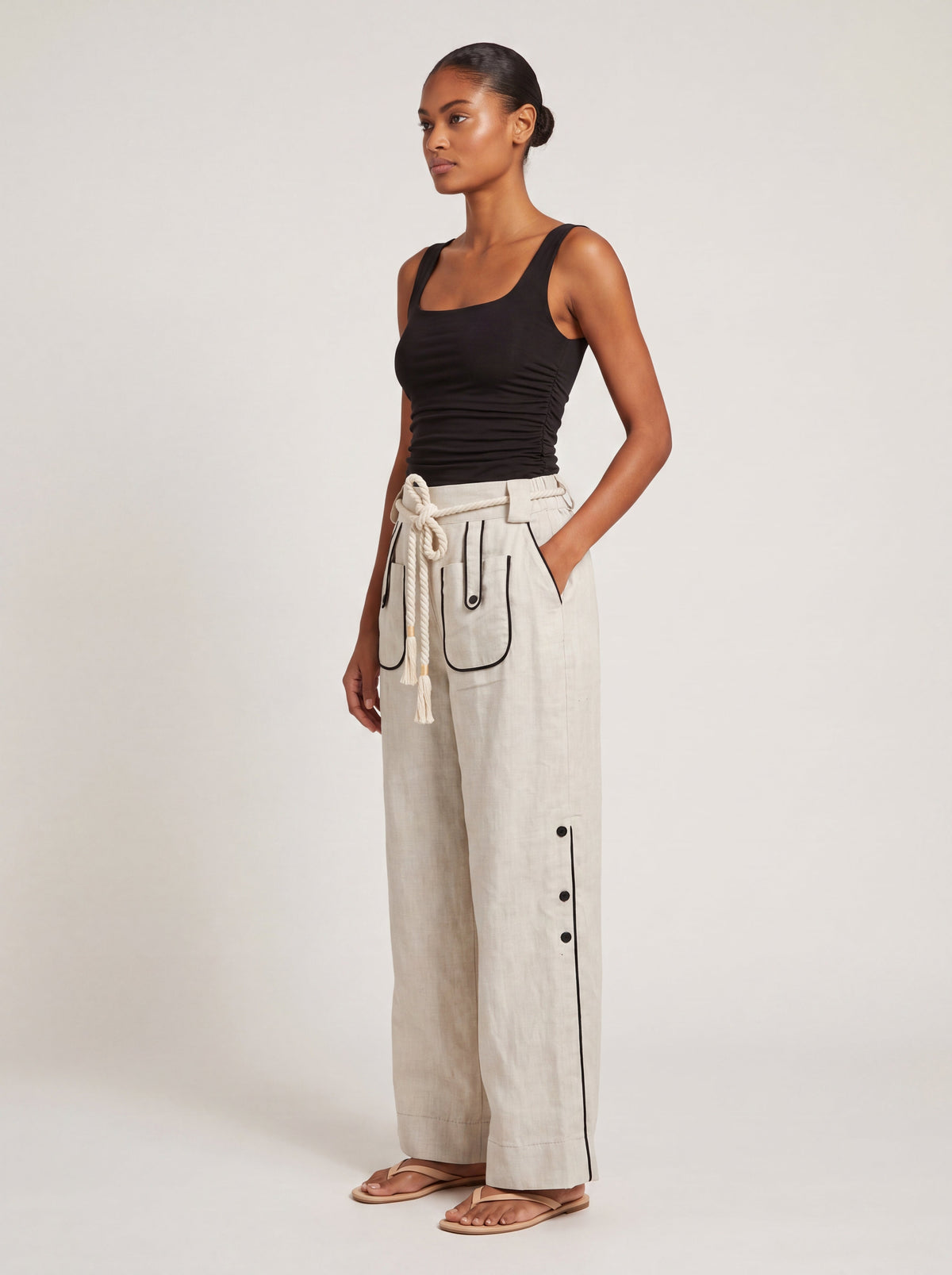 Side profile of model wearing the Aether Linen Trouser in beige