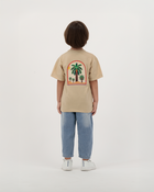 Child wearing The Palm Kids T-Shirt with palm leaf illustration.