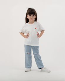 Girl in Batikh Watermelon Print Kids Tee with fruit artwork on back.