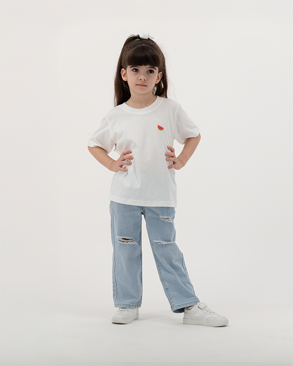 Girl in Batikh Watermelon Print Kids Tee with fruit artwork on back.