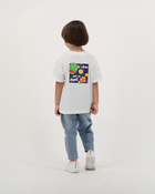 Boy dressed in white Batikh T-Shirt with playful fruit graphic on back.