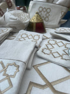 The Arabesque Table Set - 15 Piece Bronze Embroidered set from Raw Cotton placed in a handmade basket with leather handles. 