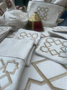 The Arabesque Table Set - 15 Piece Bronze Embroidered set from Raw Cotton placed in a handmade basket with leather handles. 
