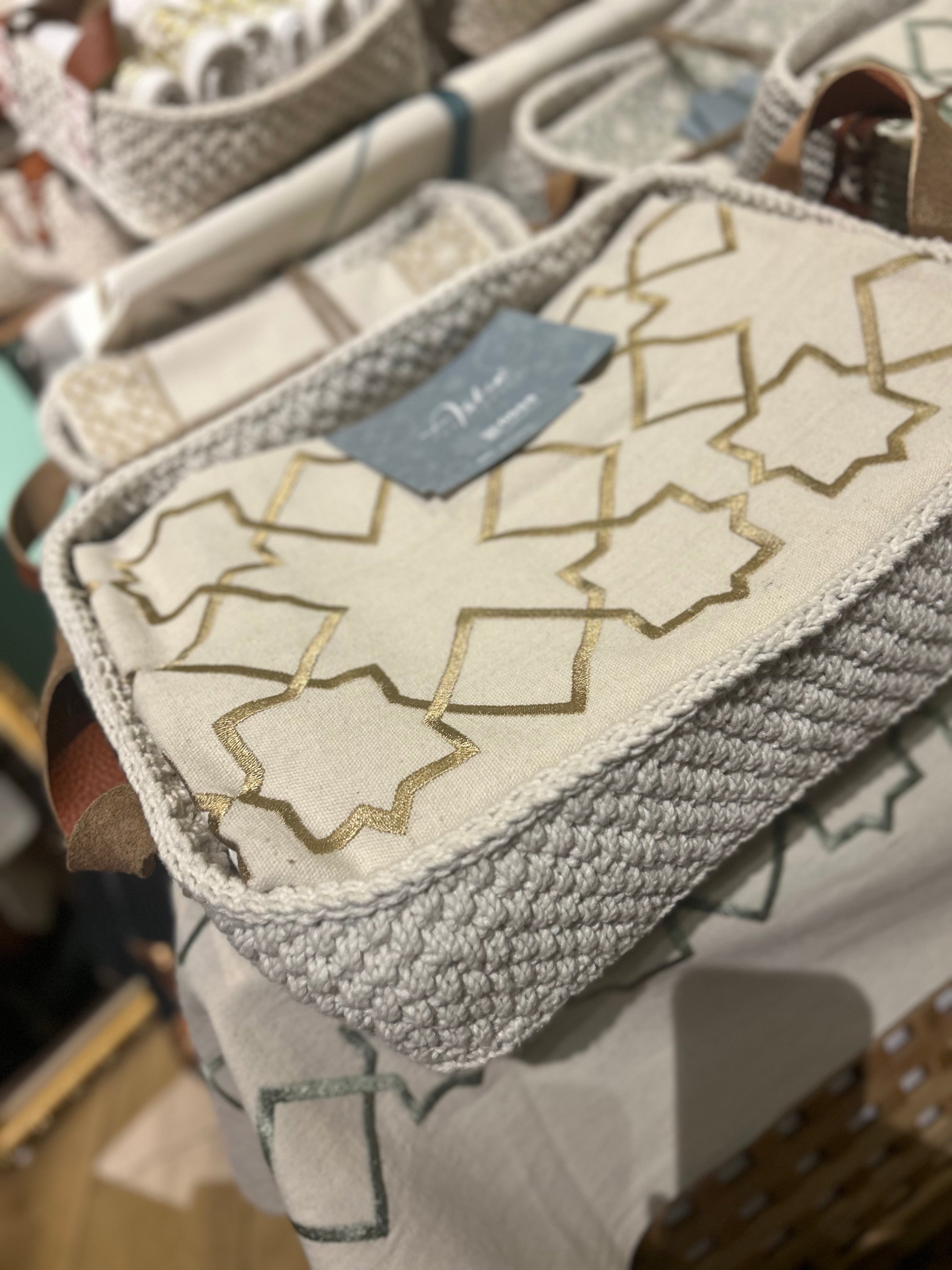 The Arabesque Table Set - 15 Piece Bronze Embroidered set from Raw Cotton placed in a handmade basket with leather handles. This picture shows the handmade basket that the set comes in with the leather handles.