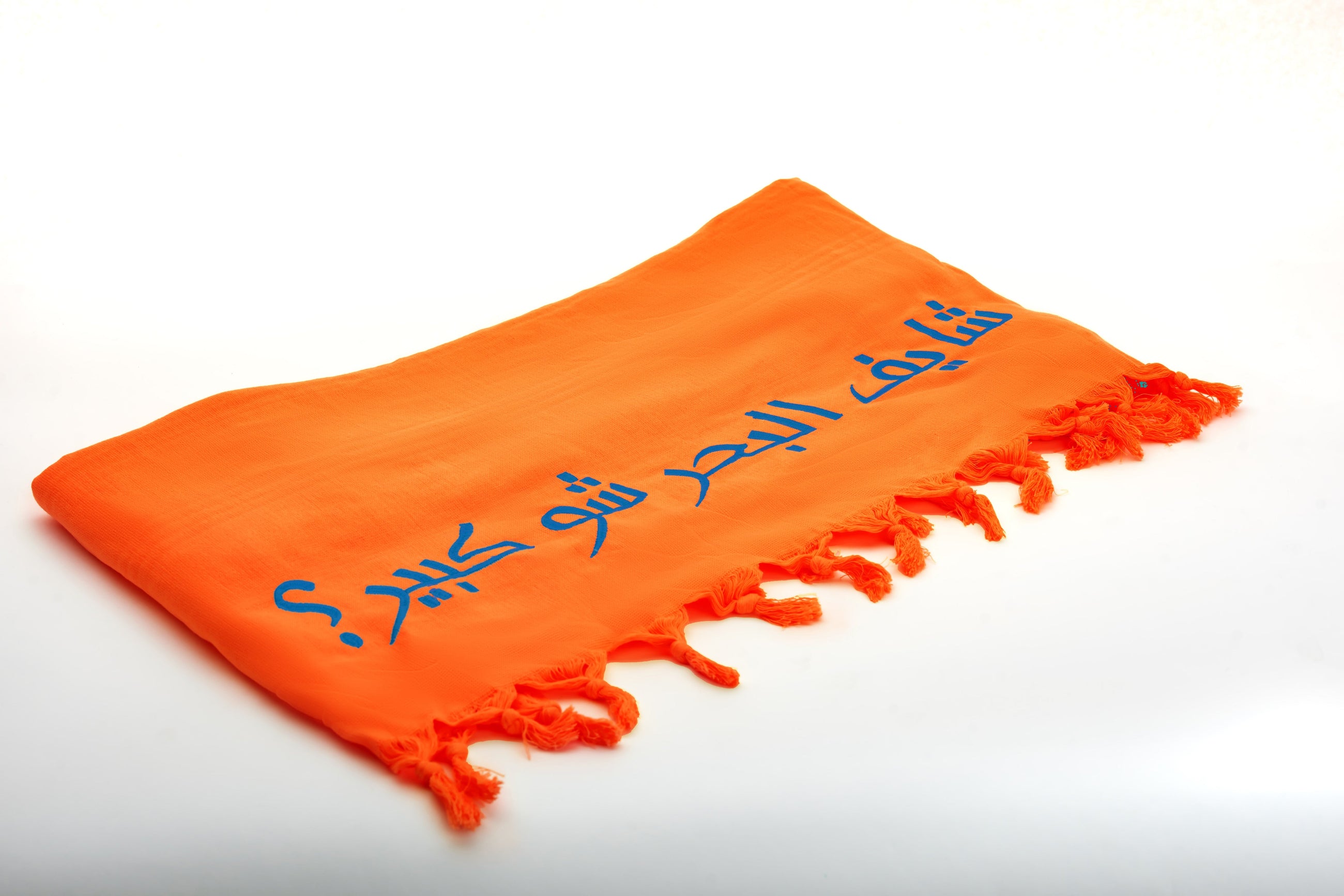 The Rio Embroidered Turkish Beach Towel in vibrant orange colour by Ashia
