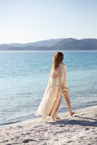 Woman walking along the beach wearing the Itza Kimono 