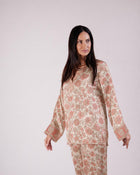 1. Front view of the Soleia peach and nude silk top showing its long sleeves and print