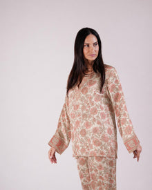 1. Front view of the Soleia peach and nude silk top showing its long sleeves and print