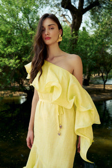 Model wearing the Hazar Azhari Sunlit Dress with a one-shoulder silhouette and cascading ruffle detailing.
