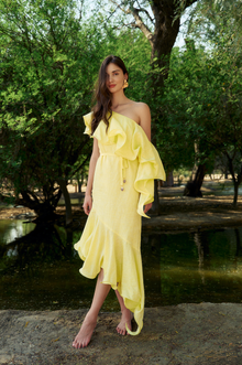 Model wearing the Hazar Azhari Sunlit Dress with a one-shoulder silhouette and cascading ruffle detailing.